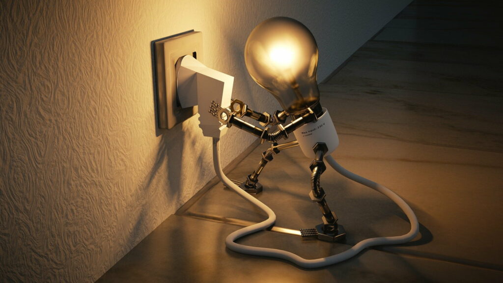 A fantasy image of a light bulb plugging in to a wall socket the cable and plug attached to the bulb