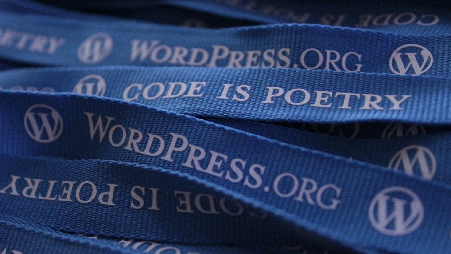 An image of many blue ribbons emblazoned with 'WordPress.org - Code is Poetry'.
